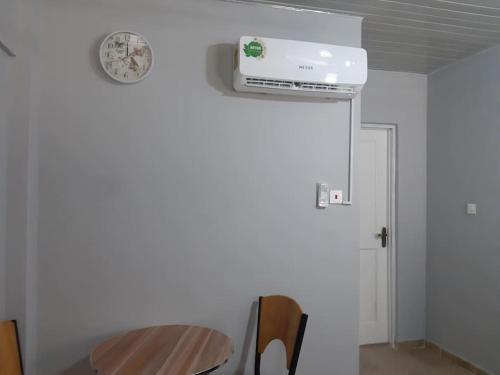 a room with a table and a clock on the wall at The Alpha* residence in Tema