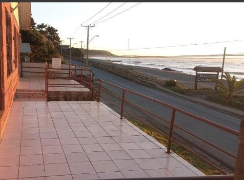 a sidewalk next to a beach with a fence at Puesta del Sol in Pelluhue