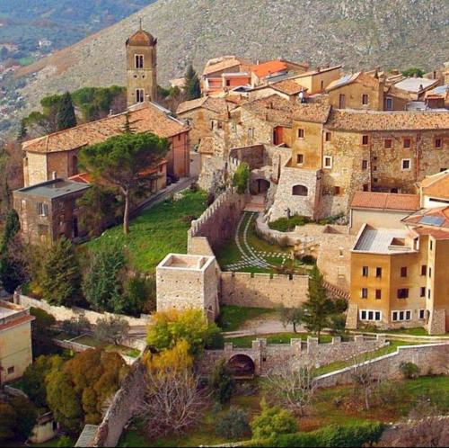 a group of buildings in a village with a church at Pink house in Fara in Sabina