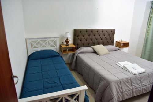 ein Schlafzimmer mit einem Bett und einem Stuhl darin in der Unterkunft Departamentos x dia Viedma 3 CON COCHERA in Viedma