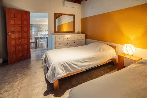 a bedroom with two beds and a mirror at Beachfront CASA SOL - closest to the sand in Ensenada