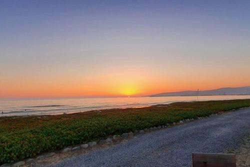 a sunset on the beach with a dirt road at Beachfront CASA SOL - closest to the sand in Ensenada