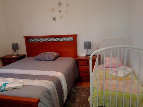 um quarto com 2 camas individuais, uma mesa de cabeceira e uma saia-cama. em Casa Monte Alegre em Redinha