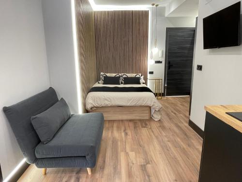 a bedroom with a bed and a couch and a television at Plaza Mayor de Salamanca By LixLoft in Salamanca