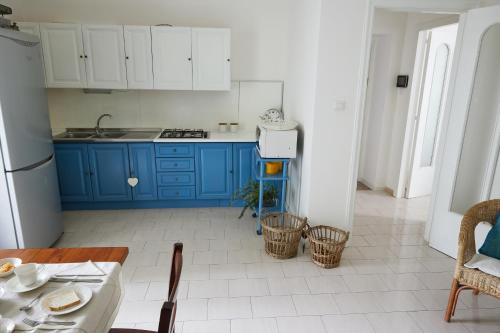a kitchen with blue cabinets and a table with a table sidx sidx at SUITE HOME VIA ROMA in SantʼAntonio Abate