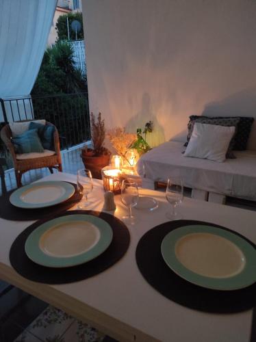 a table with two plates and wine glasses on it at SUITE HOME VIA ROMA in SantʼAntonio Abate