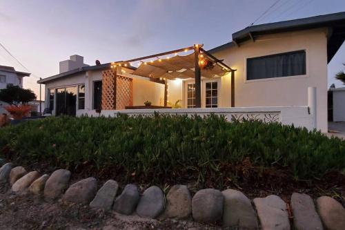 a house with a pergola with lights on it at CASA SURF - BEACHFRONT LIVING in Ensenada