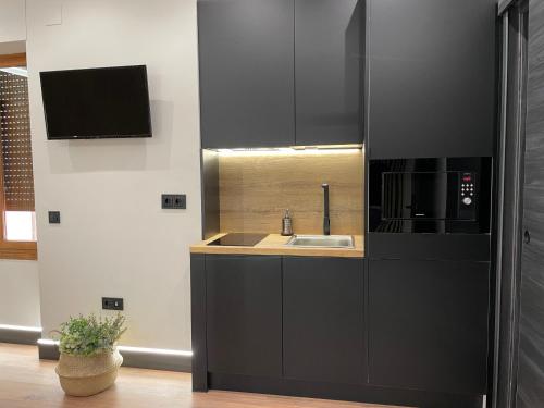 a kitchen with a sink and a microwave at Plaza Mayor de Salamanca By LixLoft in Salamanca