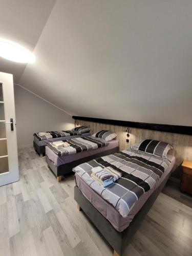 - 3 lits dans une chambre dotée de parquet dans l'établissement Zajazd Wernyhora, à Sułoszowa