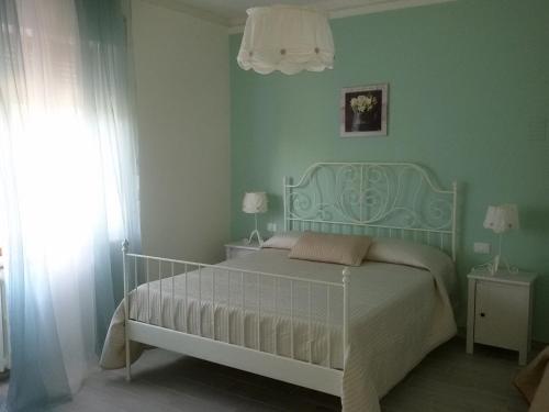 フェルモにあるB&B Il Ponte di Legnoの緑の壁のベッドルーム1室(白いベッド1台付)