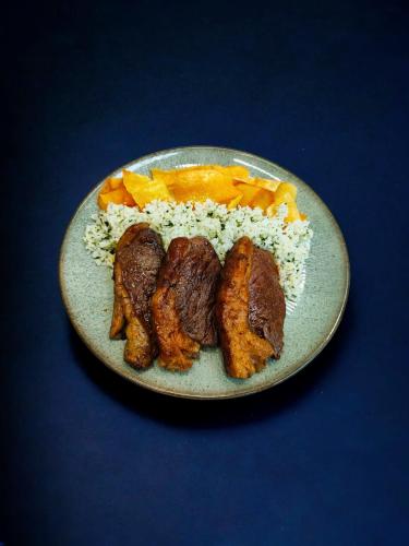 a plate of food with rice and meat and vegetables at Motel Confidence in Santo André