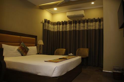 EXPRESS HOTEL في لاهور: غرفة نوم بسرير ونافذة مع ستائر
