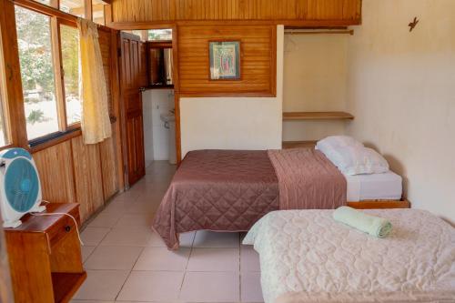 a small room with two beds and a kitchen at Cabañas Anzu in Santa Clara