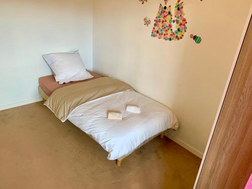 - un petit lit dans une chambre avec 2 oreillers dans l'établissement Appartement spacieux, à Drancy