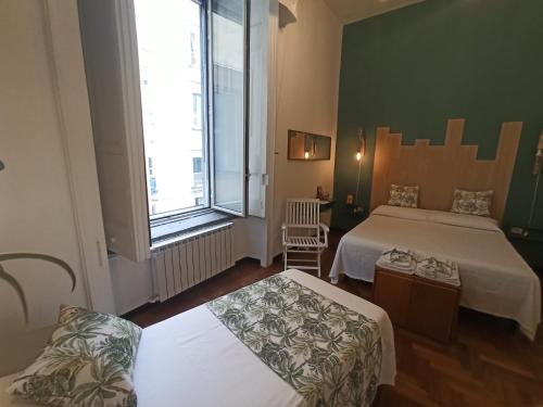 a hotel room with two beds and a window at Intrecci & Impasti in Naples