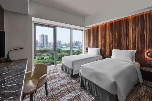 a hotel room with two beds and a window at Suz & Catorze Taipei, a Tribute Portfolio Hotel in Taipei