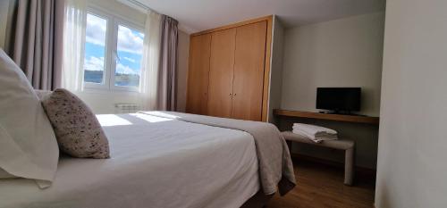 a hotel room with a bed and a window at Alma Invicta Padrões I ( w/ Private Swimming Pool) in Montalegre
