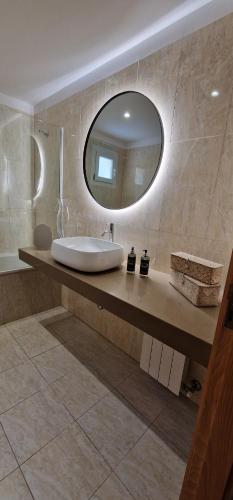 a bathroom with a sink and a mirror at Alma Invicta Padrões I ( w/ Private Swimming Pool) in Montalegre
