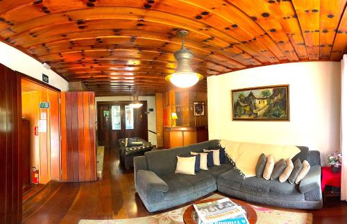 a living room with a couch and a table at Pousada Atalaia Capivari in Campos do Jordão