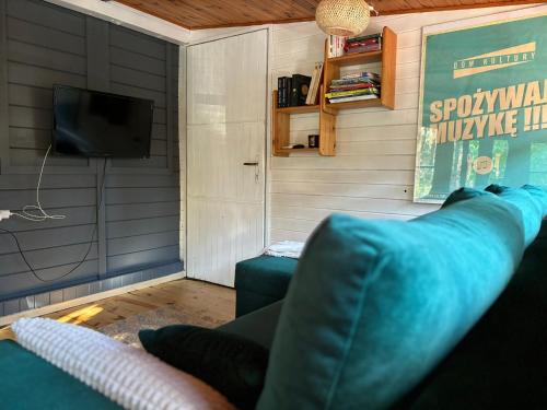 a living room with a couch and a tv at Leśny Zakątek in Krajęczyn