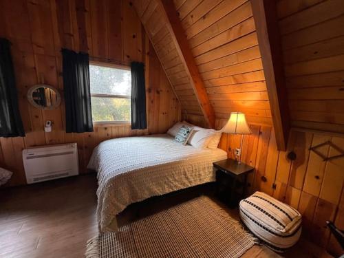 um quarto com uma cama num chalé de madeira em Knotty Pines Lodge em Bass Lake Annex