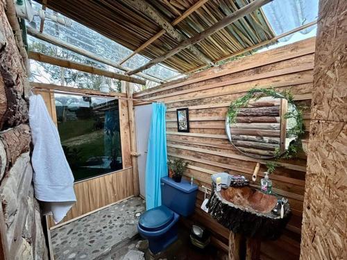 a bathroom with a blue toilet and a sink at Eco-cabaña piemonte in Guasca