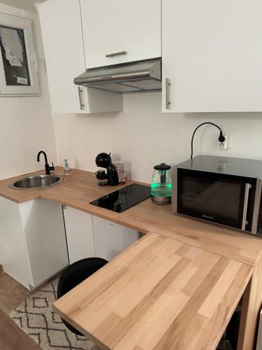 - une cuisine avec un comptoir, un four micro-ondes et un évier dans l'établissement Un studio au sacré cœur Montmartre, à Paris