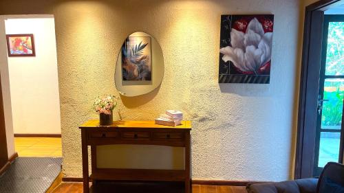 a room with a table and a mirror on a wall at Pousada Atalaia Capivari in Campos do Jordão