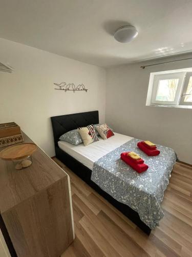 a bedroom with a bed and a table with towels on it at Libra in Okrug Gornji