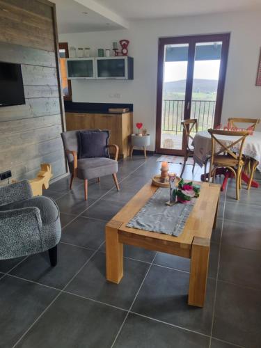 ein Wohnzimmer mit einem Tisch und Stühlen in der Unterkunft Gîte chez Alice in Mollkirch