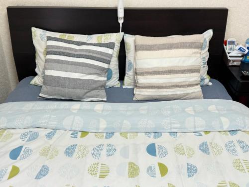 浦安的住宿－Grandeur Imagawa - Vacation STAY 11149，一张带两个枕头和蓝色棉被的床