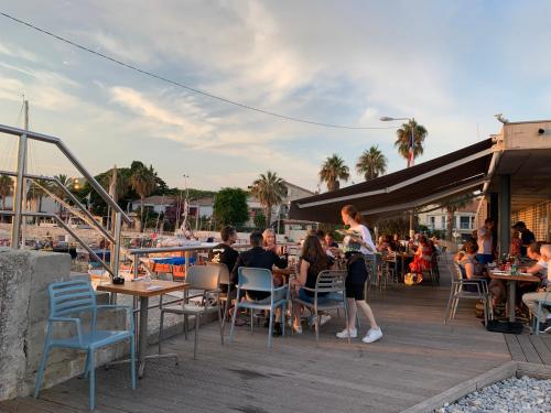 un groupe de personnes assises à des tables sur une terrasse dans l'établissement Sea view front beach apartment deluxe near Nice airport, à Cagnes-sur-Mer