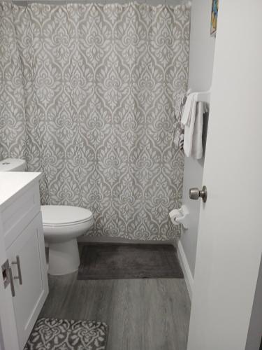 a bathroom with a toilet and a shower curtain at Nard Jolie Kay in Kissimmee