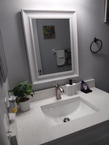a bathroom with a white sink and a mirror at Nard Jolie Kay in Kissimmee