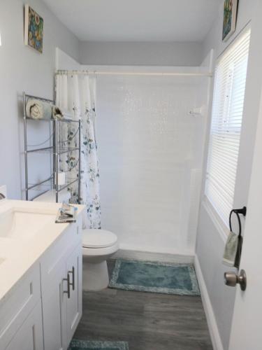 a white bathroom with a toilet and a shower at Nard Jolie Kay in Kissimmee