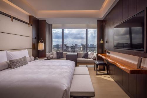 ナイロビにあるJW Marriott Hotel Nairobiのベッドと大きな窓が備わるホテルルームです。