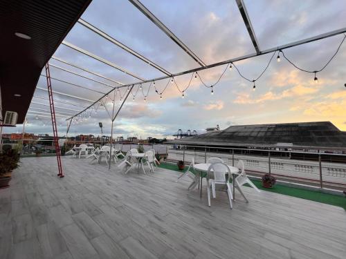 una terraza con sillas blancas y mesas en un barco en Hotel Internacional de Colón, en Colón