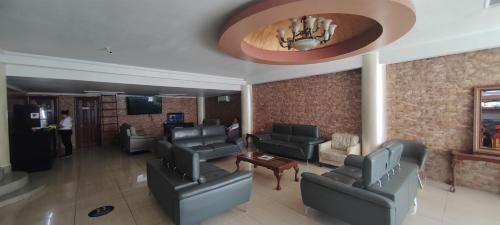 a lobby with couches and chairs and a television at Hotel Internacional de Colón in Colón