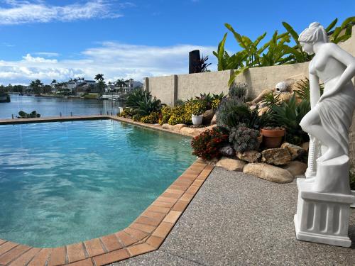 a statue of a woman standing next to a swimming pool at Waterfront BNB in Gold Coast
