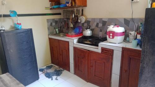 a kitchen with wooden cabinets and a stove top oven at Griya PAS Pangandaran in Pangandaran