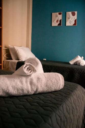 a bedroom with two beds and a blue wall at AXD Pulse Apartment in Alexandroupoli