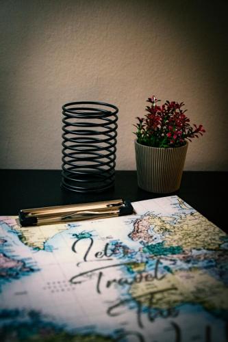 a table with a notebook and a plant and a pen at AXD Pulse Apartment in Alexandroupoli