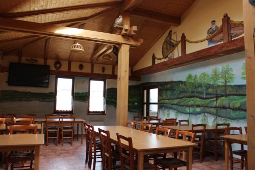 a restaurant with tables and chairs and a painting on the wall at Marine Závlahy in Hrdějovice
