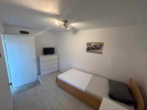 a small bedroom with a bed and a tv at Family house Aldo in Rogač