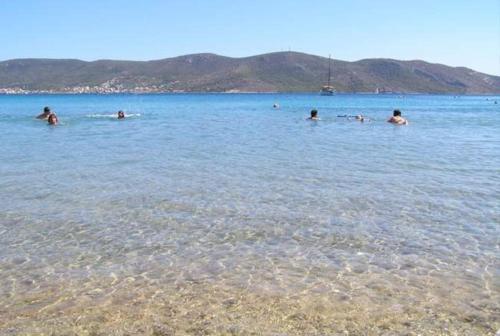 a group of people swimming in a body of water at Beautiful lux Villa Ilias Salamina in Salamís