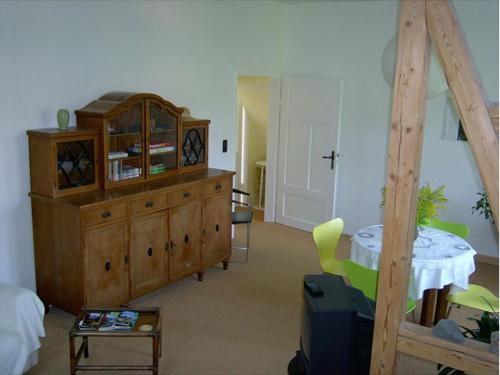 een woonkamer met een houten dressoir en een tafel bij Waldhaus in Wernigerode