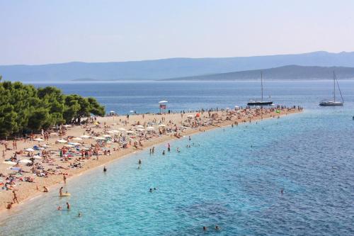 a group of people on a beach in the water at Apartments with a parking space Murvica, Brac - 22780 in Bol