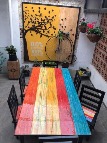 uma mesa colorida com cadeiras e uma bicicleta na parede em Belen em Popayán