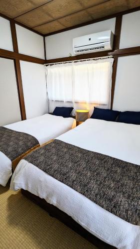 a bedroom with three beds in a room at Animal Art Apartment 201 in Ogikubo