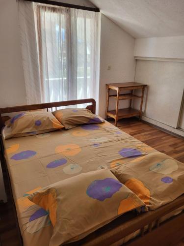 ein Schlafzimmer mit einem Bett mit einer Decke darauf in der Unterkunft Vreshtat e Liqenit-Ezerski Llozja in Struga